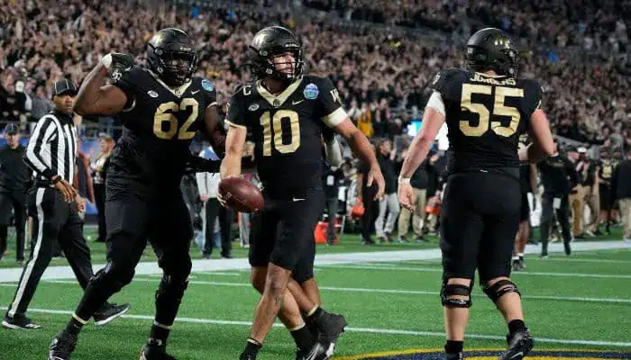 Purdue football players Jay Fiedler and teammate celebrate a touchdown during a game against Michigan State.