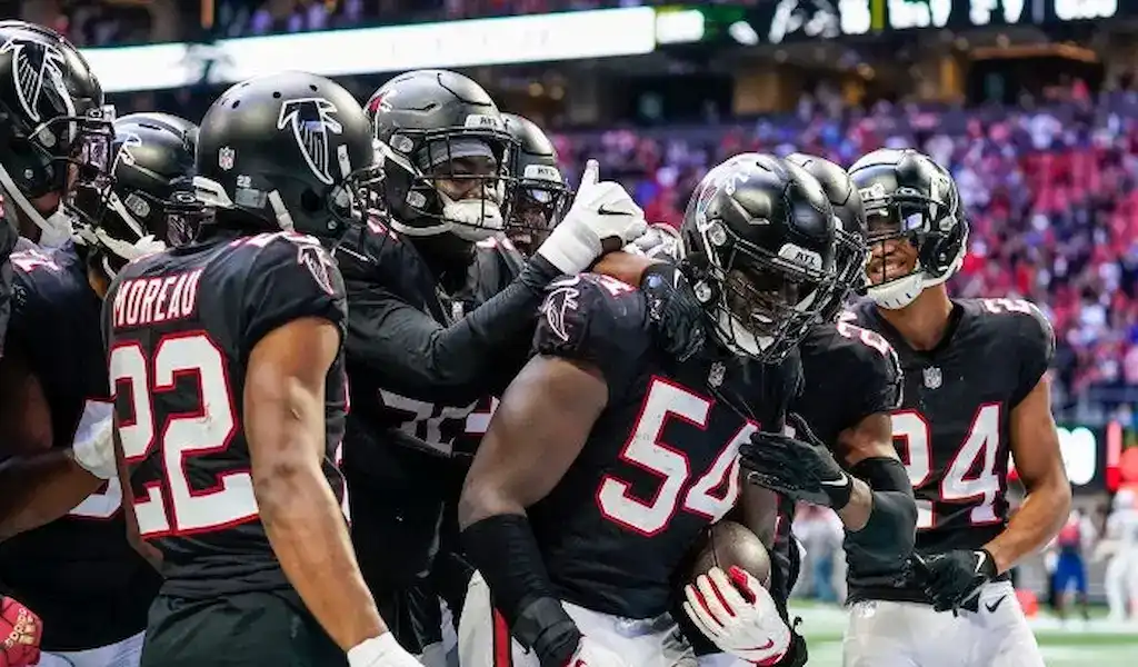 Gambling News 7 Atlanta Falcons players celebrating together on the field during an NFL game.
