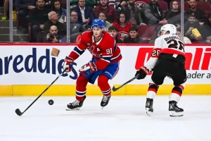 A player from the Montreal Canadiens handling the puck while being defended by a player from the Ottawa Senators
