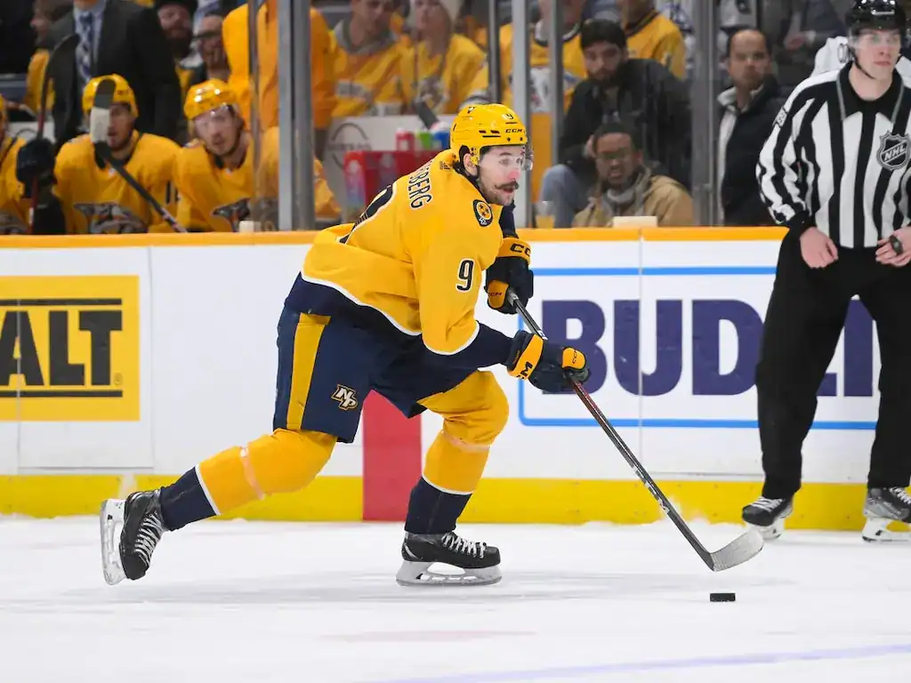 Nashville Predators hockey player skating with the puck during a game.