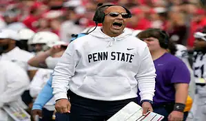 Penn State Nittany Lions head coach shouts instructions from the sideline during a college football game.
