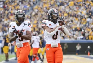 Oklahoma State football players celebrate in the end zone after a touchdown.