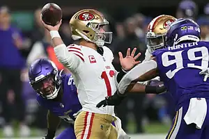 San Francisco 49ers quarterback throws under pressure from Vikings.
