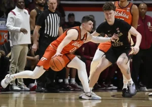 A Virginia Tech player dribbles the ball while closely guarded by a Florida State.