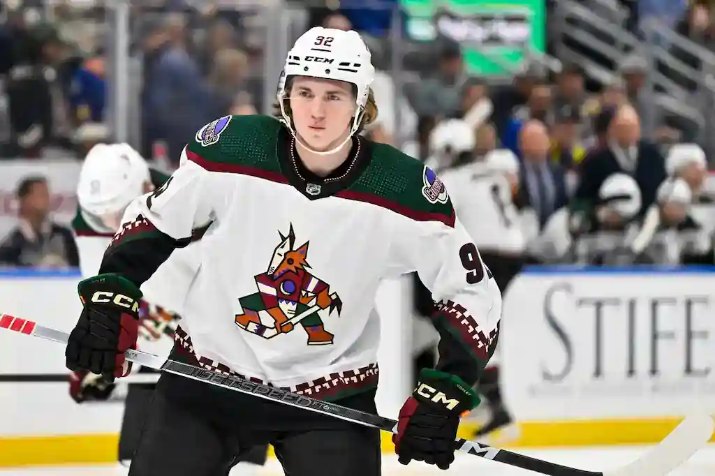 NHL 8 An Arizona Coyotes player skates during warmups, wearing a white jersey with the team’s coyote logo.