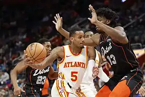 Atlanta Hawks player drives past Detroit Pistons defender.