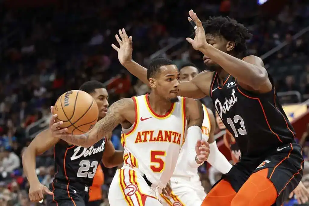 Atlanta Hawks player drives past Detroit Pistons defender.