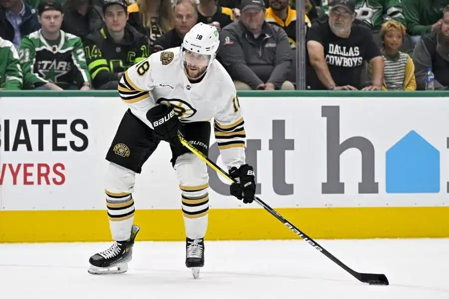 NHL 4 Boston Bruins player Karl Marsson in action on the ice during a hockey game, wearing team colors and gear.