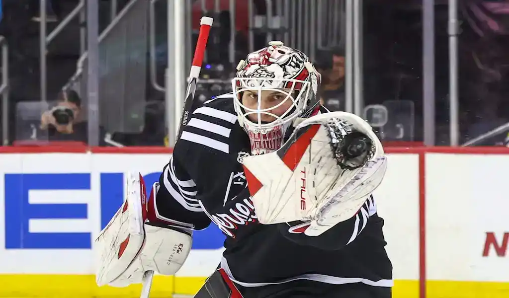 NHL 4 New Jersey Devils goalie makes a glove save during a November 25, 2023, NHL game against the Buffalo Sabres.
