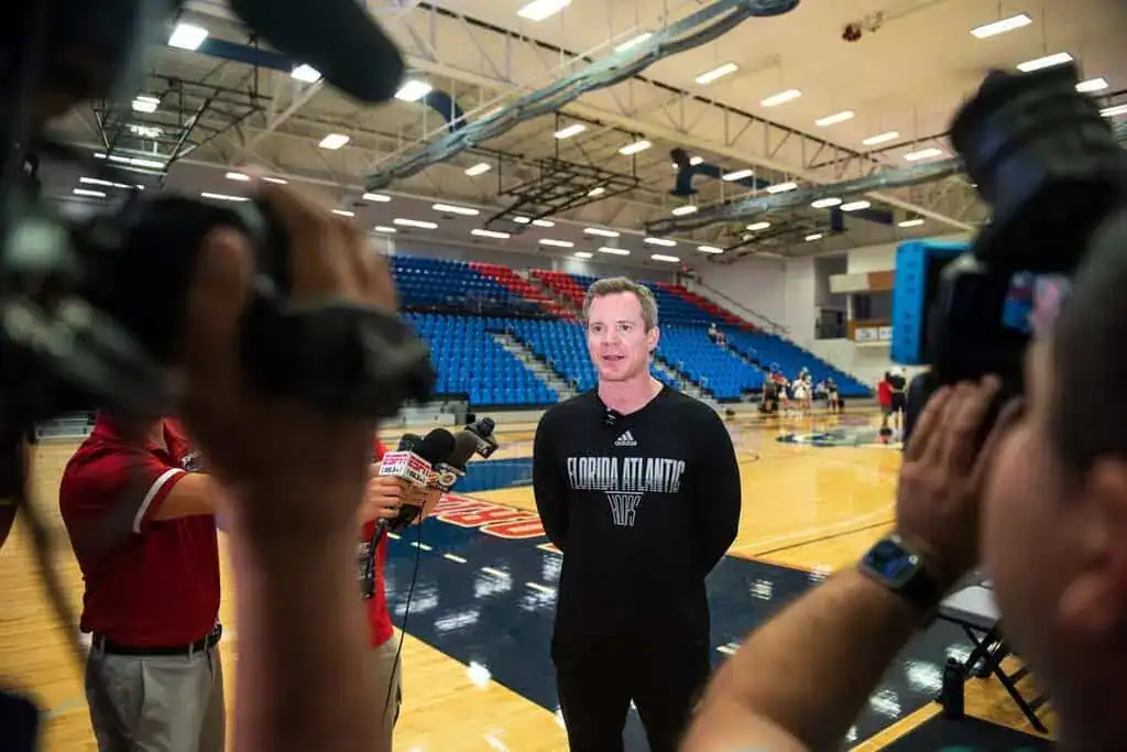 Florida Atlantic coach speaks to media in gym.