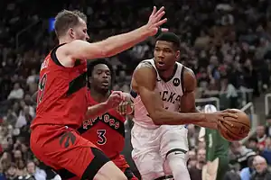 Milwaukee Bucks star Giannis Antetokounmpo drives toward the basket for a layup against Toronto Raptors defenders.