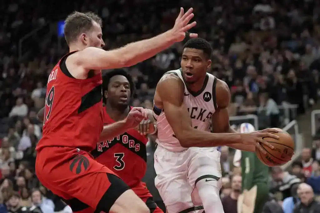 Milwaukee Bucks star Giannis Antetokounmpo drives toward the basket for a layup against Toronto Raptors defenders.