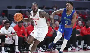 Houston guard dribbles past a defender with speed during a transition play