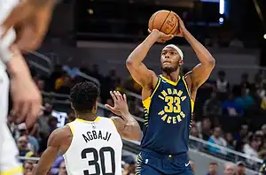 Indiana Pacers player in a navy jersey with number 33 rises to take a jump shot over a defender.