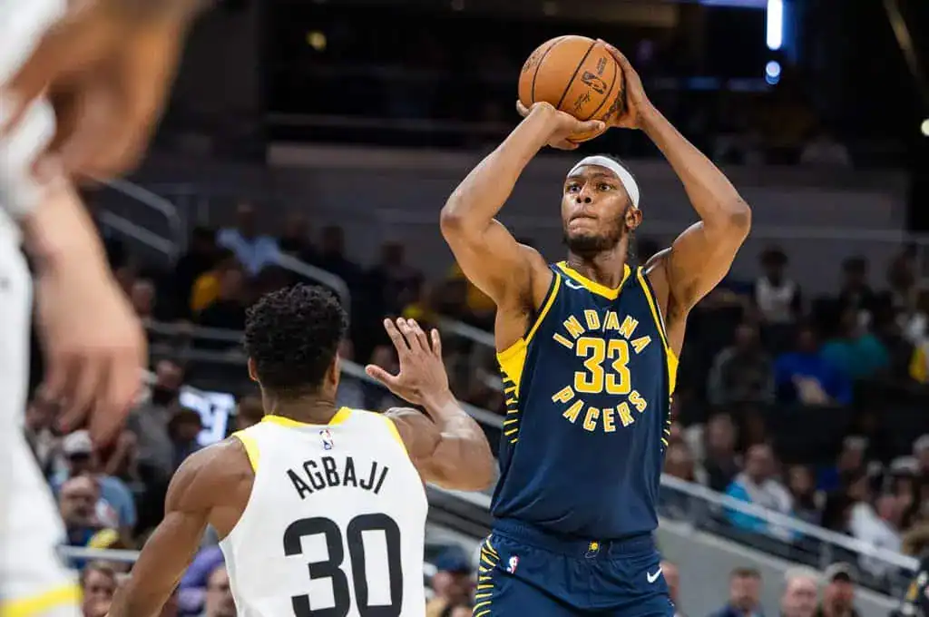 Indiana Pacers player in a navy jersey with number 33 rises to take a jump shot over a defender.