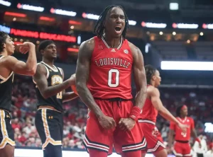 Louisville Cardinals player number 0 roars and flexes his arms in celebration.