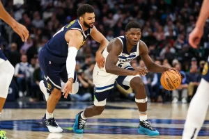 A Minnesota Timberwolves player dribbles the ball with intensity.
