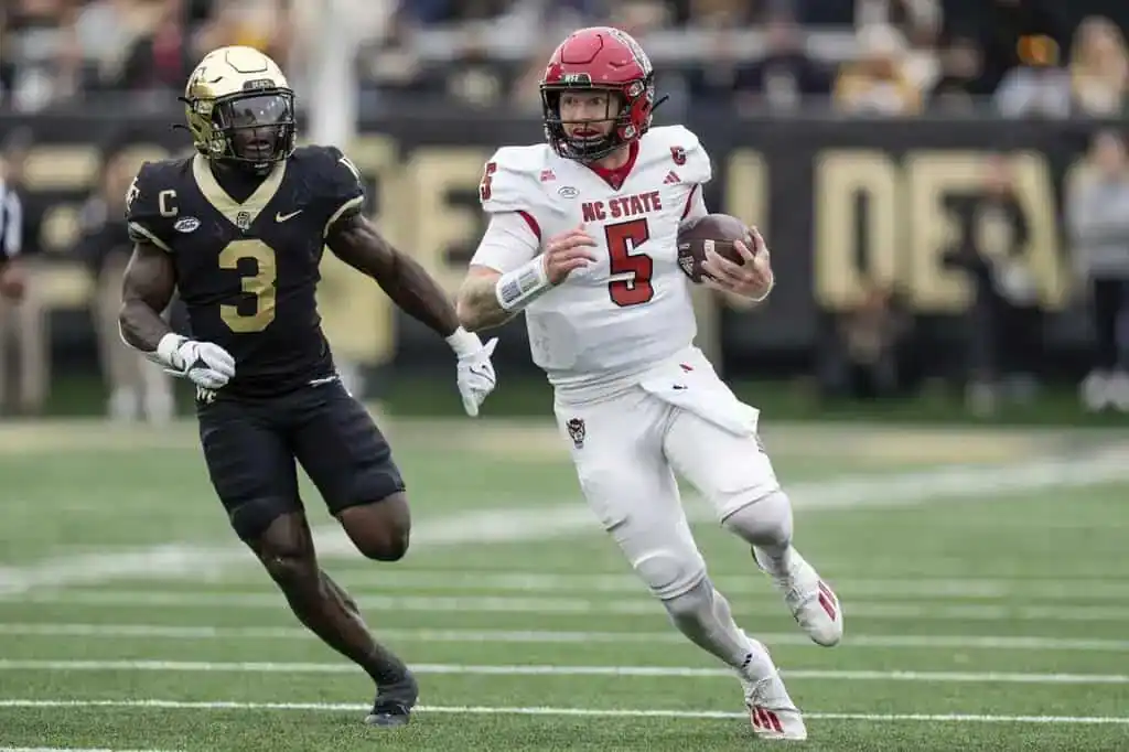 NC state player carrying the ball and opponent chasing