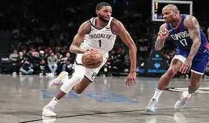 Brooklyn Nets player drives past Washington Wizards defender during NBA game on November 12, 2023