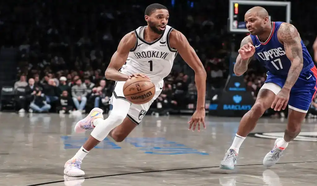 5 Brooklyn Nets player drives past Washington Wizards defender during NBA game on November 12, 2023