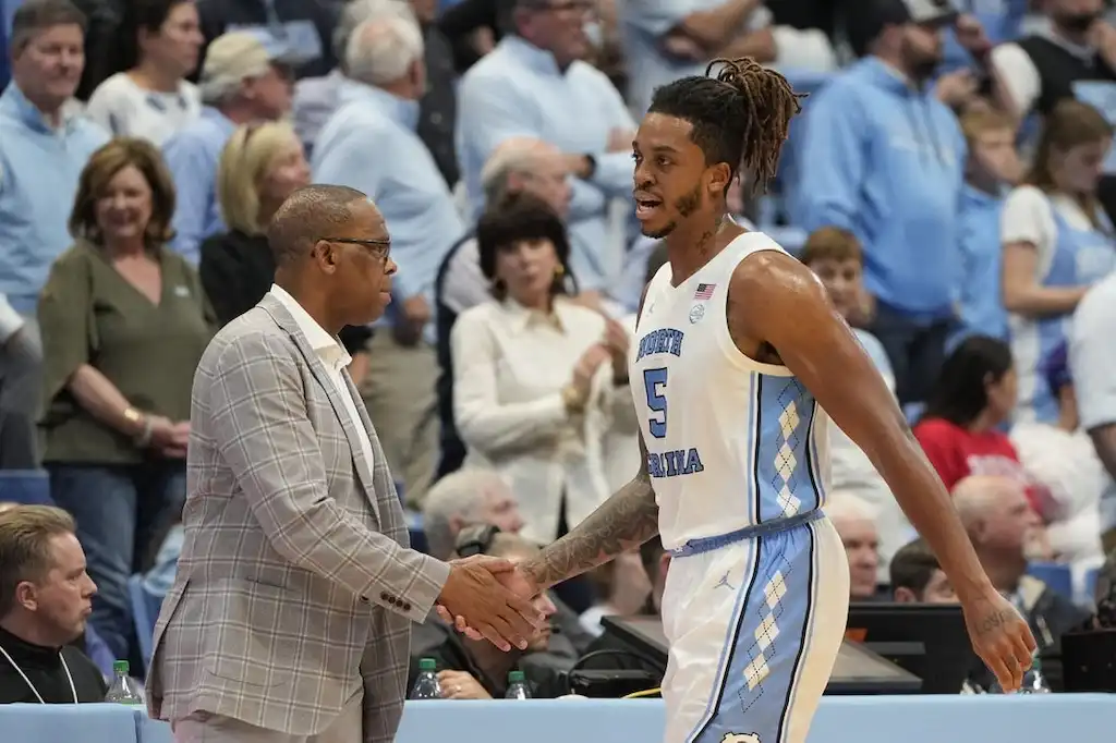 NCAAB 6 A North Carolina basketball player shakes hands with a coach.