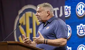 Auburn Tigers coach speaks at the podium during SEC media event ahead of matchup against Notre Dame Fighting Irish.