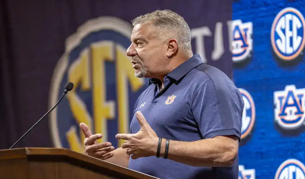 Auburn Tigers coach speaks at the podium during SEC media event ahead of matchup against Notre Dame Fighting Irish.