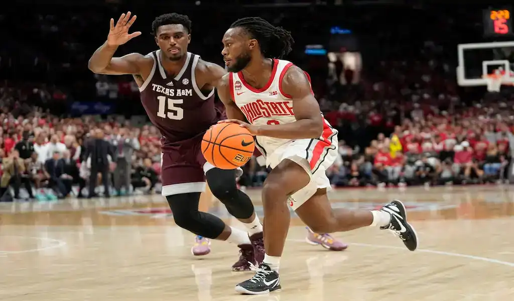 Ohio State Buckeyes basketball player drives to the basket against Merrimack Warriors defender during their November 15, 2023 matchup.