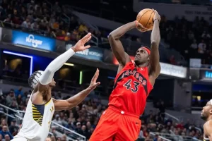 Toronto Raptors player, number 43, jumps to take a shot during a basketball game.