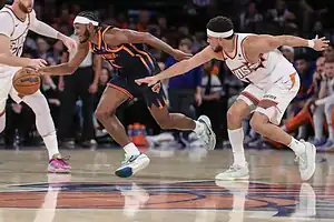 The nba players are playing basketball in a game.