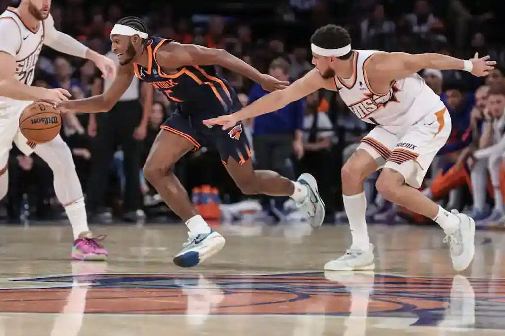 The nba players are playing basketball in a game.
