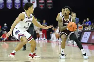Texas A&M guard squares up for a jump shot while being guarded by a Florida Atlantic player.