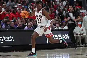 Texas Tech guard dribbles up the court with focus, looking to create an offensive play.