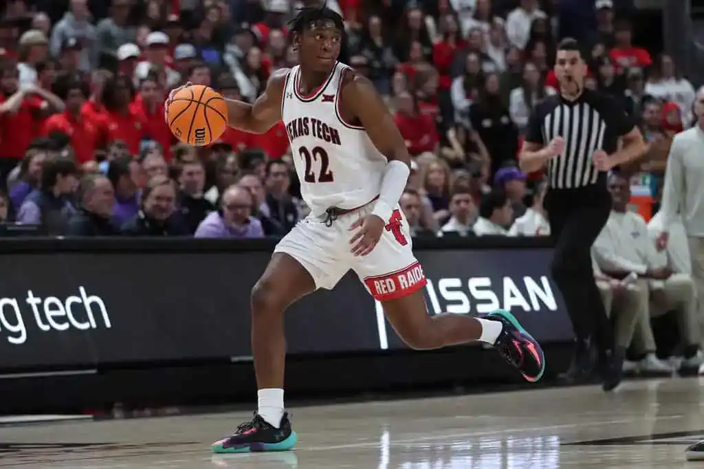 Texas Tech guard dribbles up the court with focus, looking to create an offensive play.