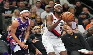 Portland Trail Blazers player drives to the basket against Utah Jazz defender during an NBA matchup.
