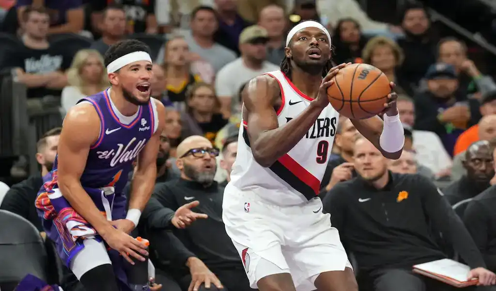 Portland Trail Blazers player drives to the basket against Utah Jazz defender during an NBA matchup.