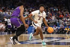 Virginia Cavaliers player (#2) driving the ball against a defender.
