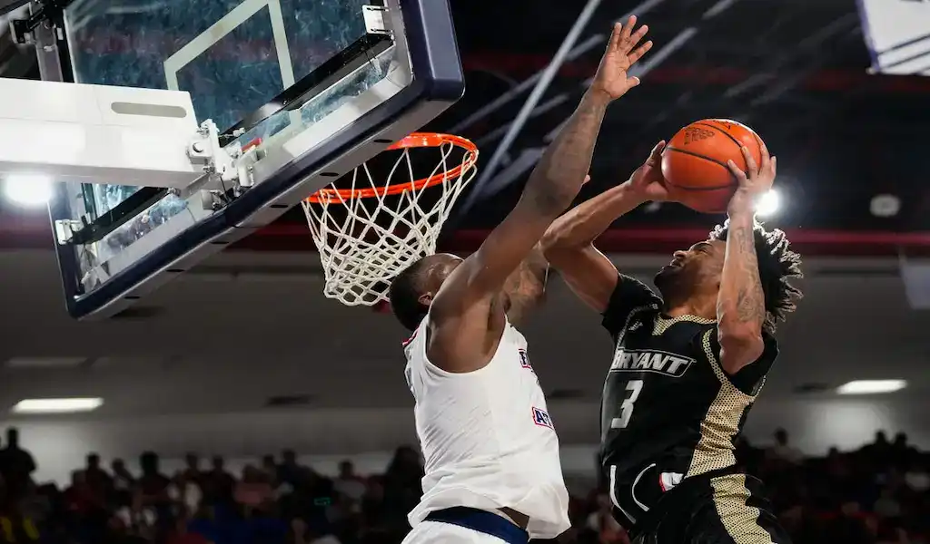 Bryant Bulldogs player drives to the basket against Xavier Musketeers defender during NCAA basketball game, November 24, 2023.