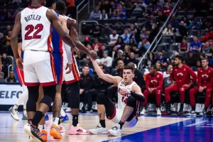 hawks player getting up with help from one of his teammates