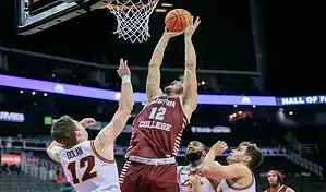 Boston College Eagles player dunks over NC State Wolfpack defenders during NCAA basketball game on December 2, 2023.