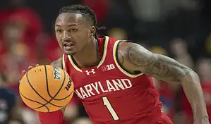 Maryland Terrapins player dribbles the ball while driving up the court during a college basketball game.