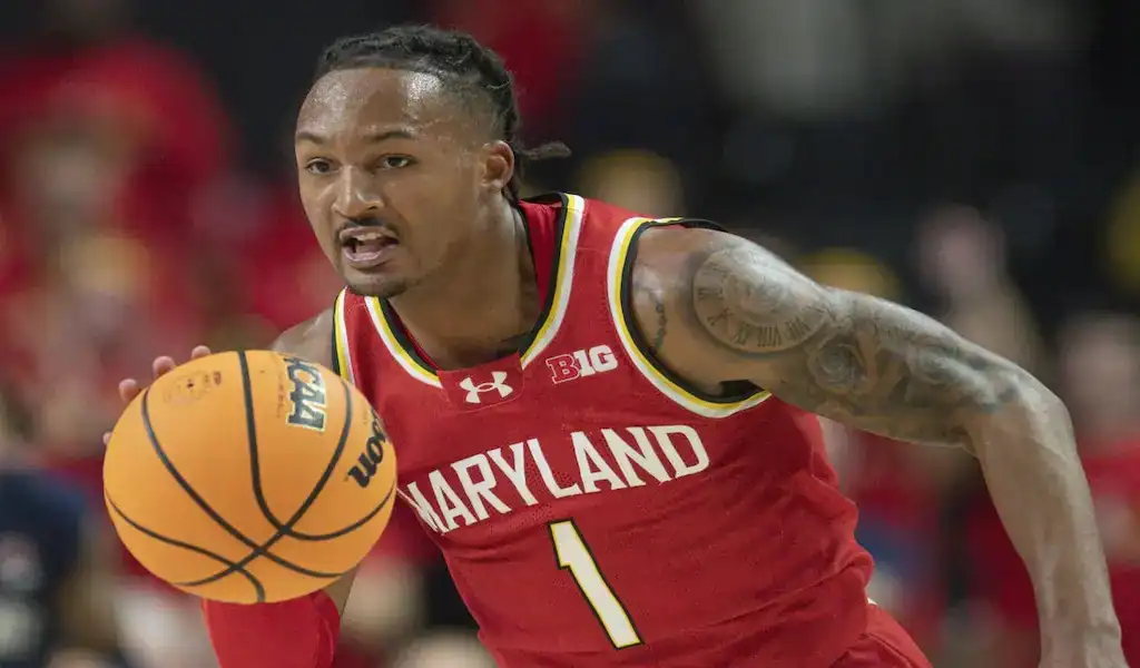 Maryland Terrapins player dribbles the ball while driving up the court during a college basketball game.