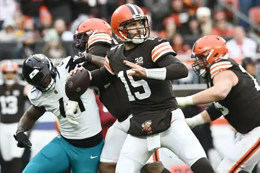 Browns quarterback prepares to throw the football under defensive pressure during an NFL game.