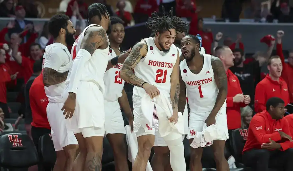 Houston Cougars basketball players celebrating on the bench during a college basketball game.