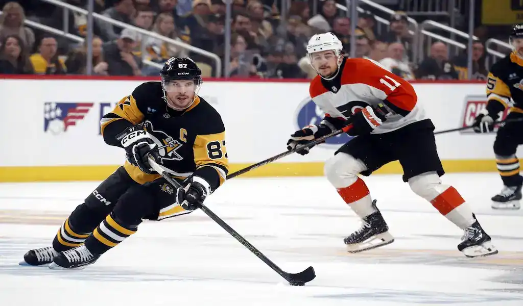 Pittsburgh Penguins and Philadelphia Flyers players battle for the puck during their December 4, 2023 NHL matchup.