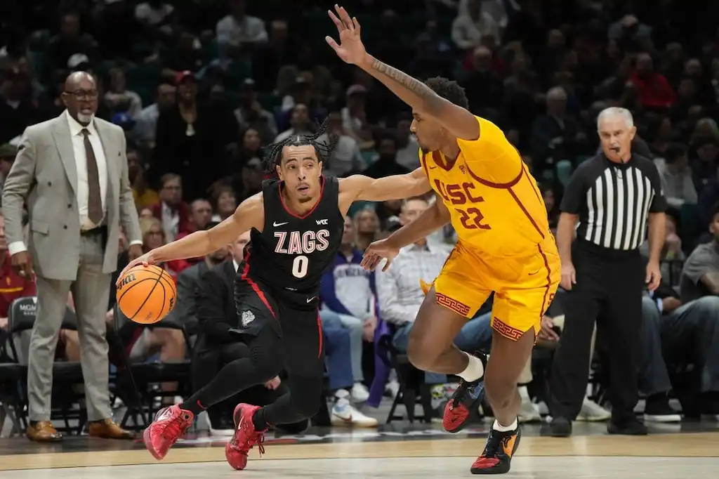 Gonzaga player drives past a defender during a college basketball game.
