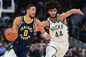 Indiana Pacers guard Tyrese Haliburton dribbles past a Milwaukee Bucks defender during an NBA game.