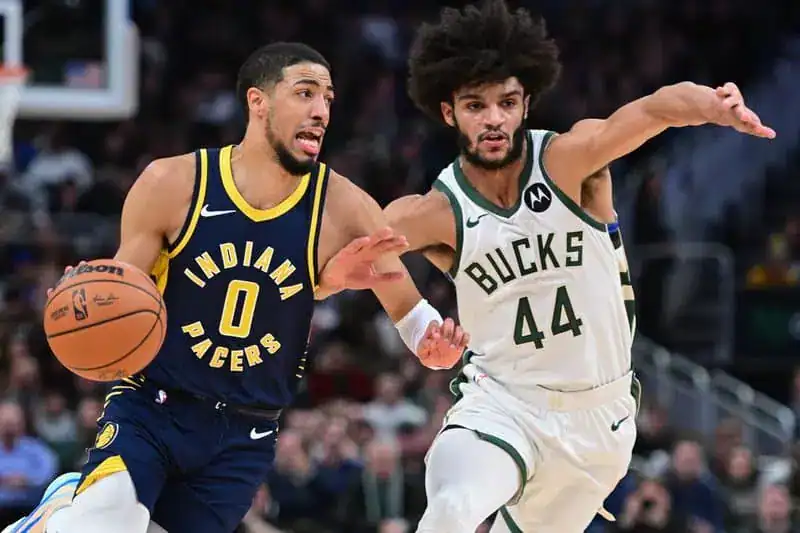 Indiana Pacers guard Tyrese Haliburton dribbles past a Milwaukee Bucks defender during an NBA game.