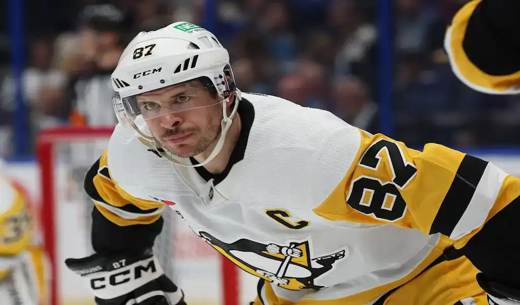 Pittsburgh Penguins player focused during a faceoff against the Florida Panthers in an NHL game.