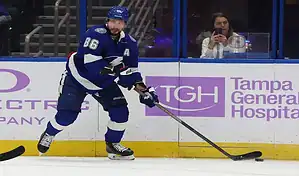 Tampa Bay Lightning player skating with the puck against the Pittsburgh Penguins during an NHL game on December 6, 2023.